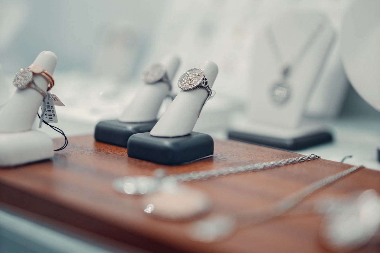 A jewelry display with diamond rings on ring busts and necklaces in the background.