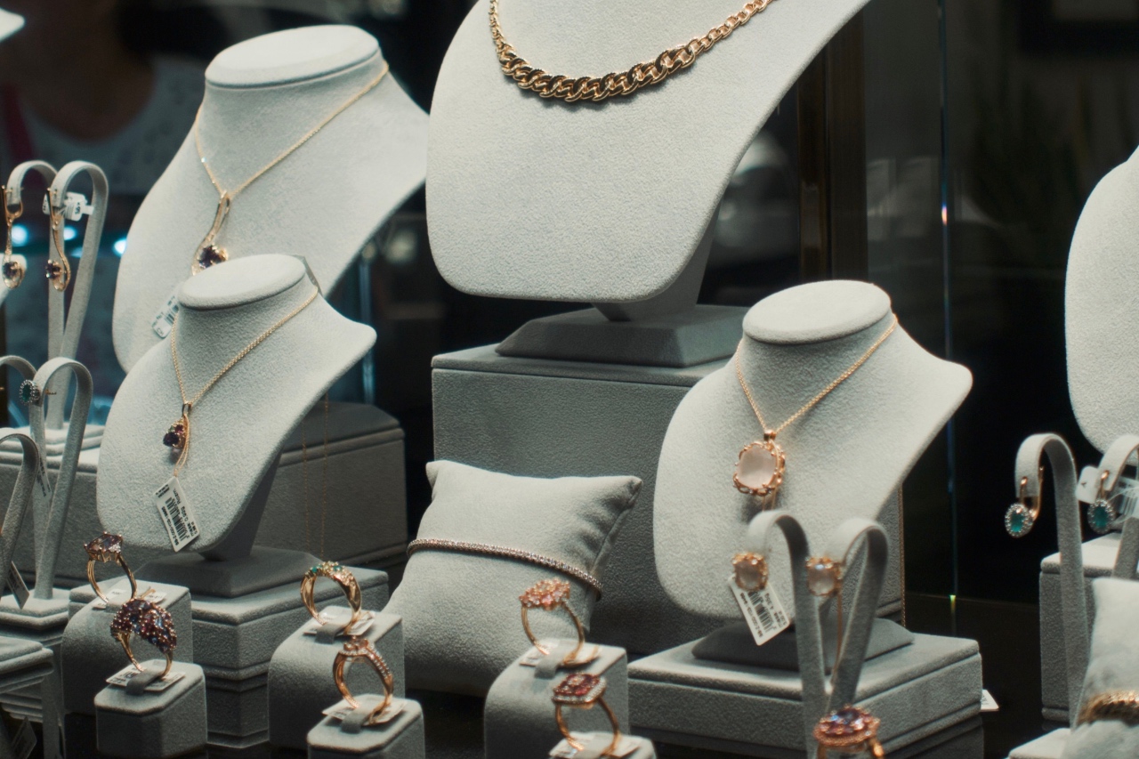 A jewelry window display with different kinds of gold jewelry on various busts and cushions.