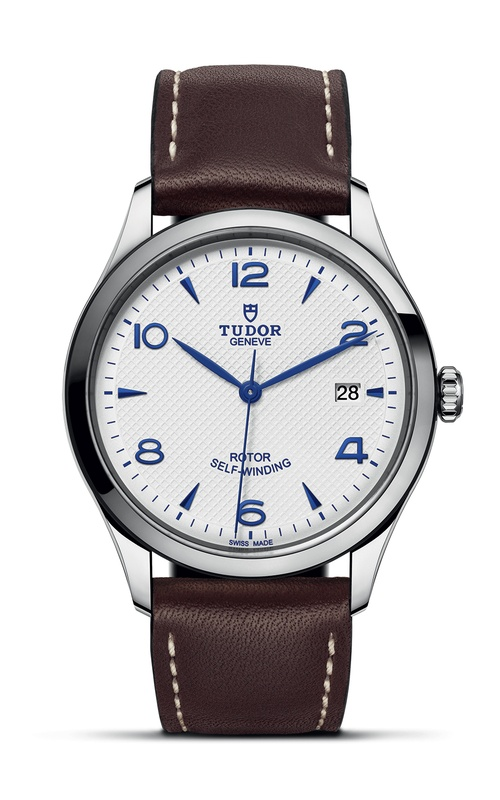 A TUDOR watch with brown leather strap, white dial with blue numbers and indexes.