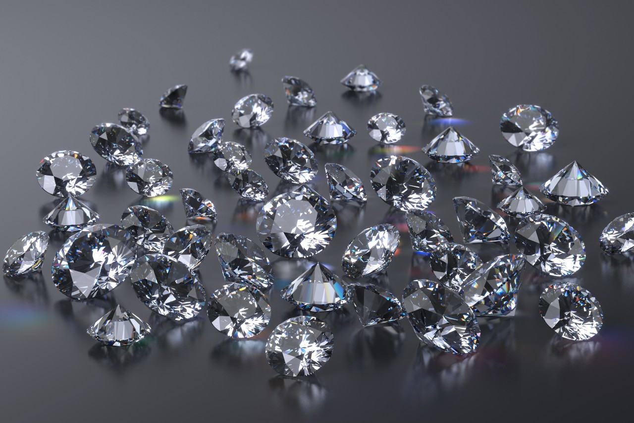Multiple diamonds scattered on a reflective grey surface