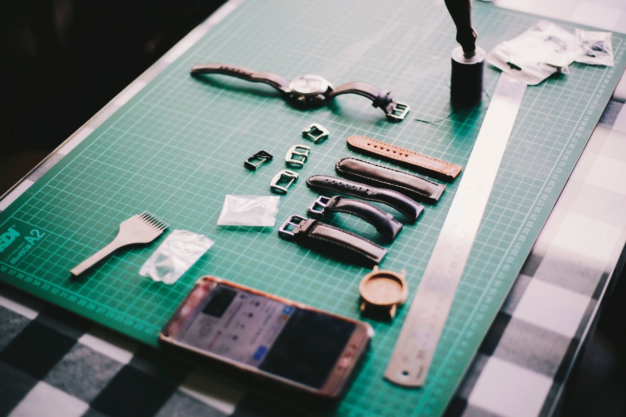 A wide top-down view of an artisan’s work desk as they prepare to maintain a luxury watch.