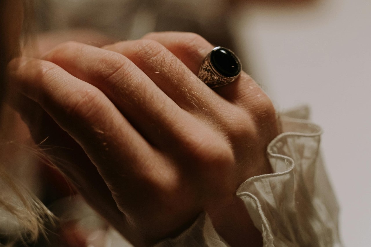 a woman’s hand adorned with a silver and black onyx ring a woman’s hand adorned with a silver and black onyx ring
